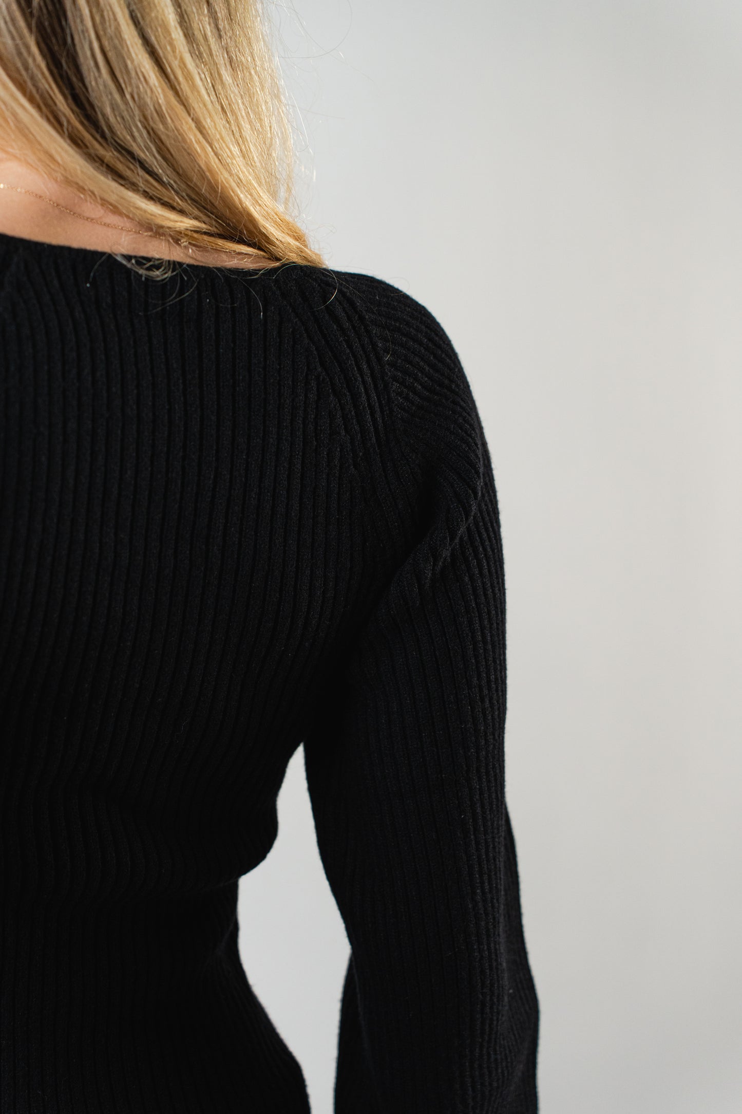 Close-up of the ribbed knit texture on the black Olivia Ribbed Sweater.