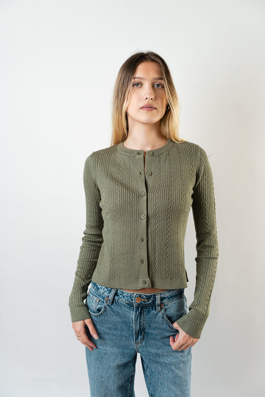 Model wearing the olive Celine Cable Knit Cardigan, a textured button-up knit sweater.