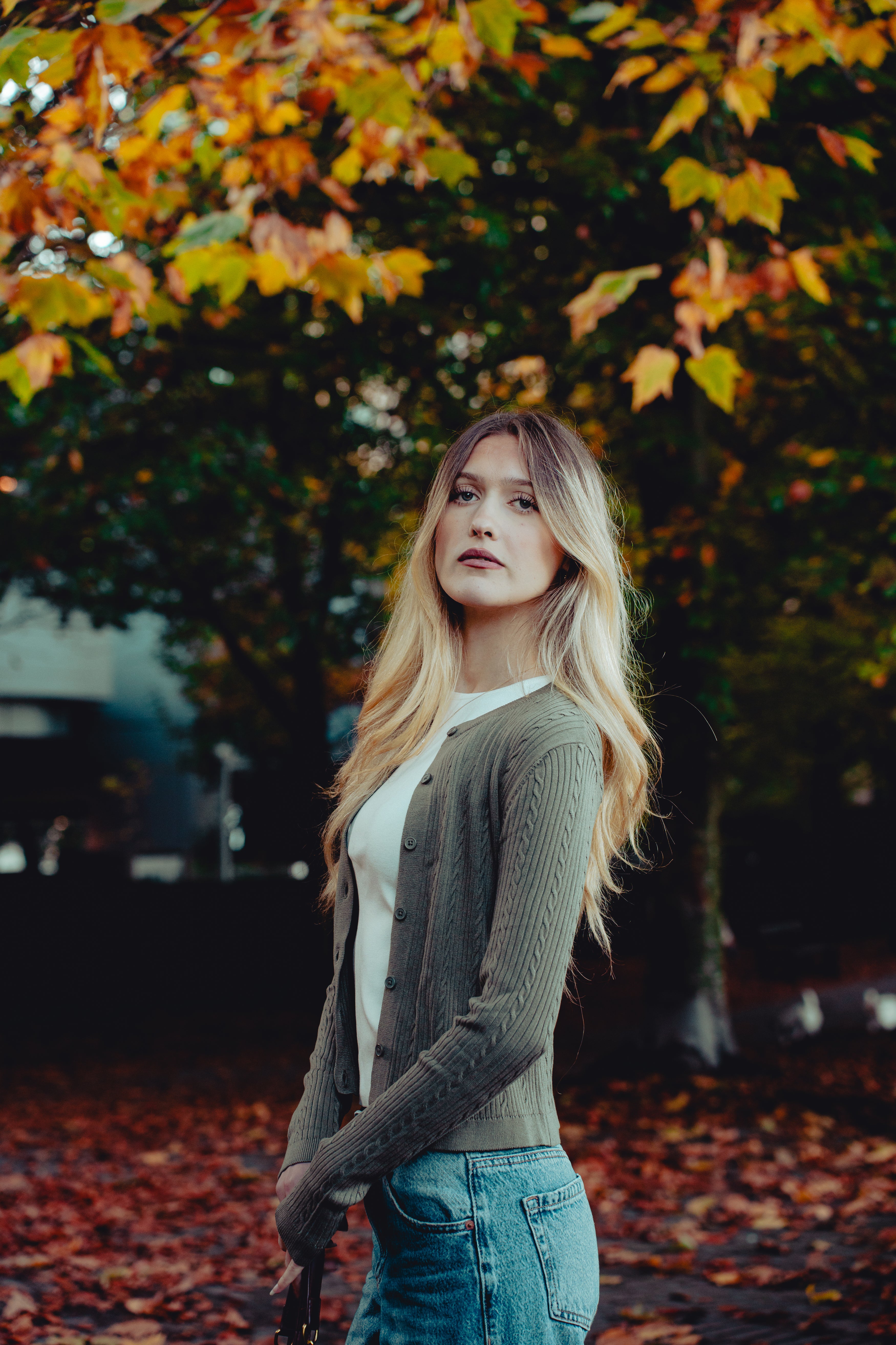 Woman standing in front of a tree with autumn leaves